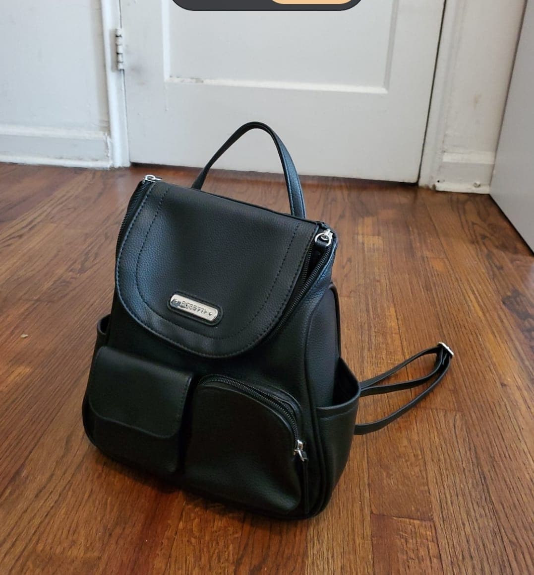 Raw Android phone product photo of a black backpack on a wooden floor before Portrait Drop